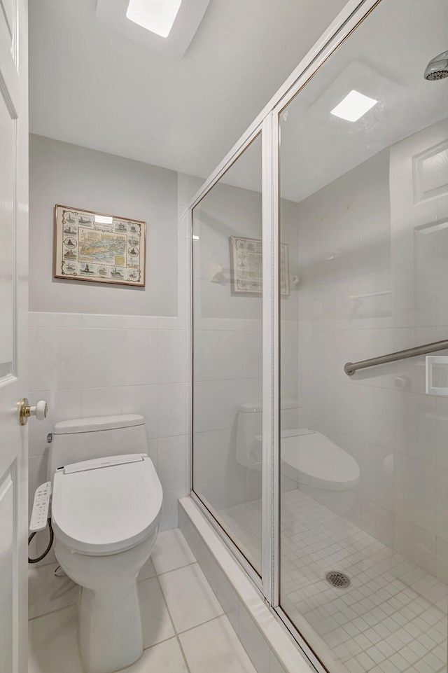 2400 S Ocean Dr Unit C623, Hutchinson Island, FL 34949 - bathroom featuring toilet, a stall shower, tile walls, a wainscoted wall, and tile patterned floors