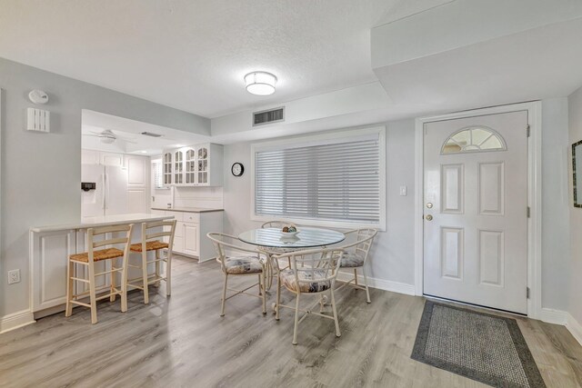 2400 S Ocean Dr Unit C623, Hutchinson Island, FL 34949 - dining area with light wood-type flooring, baseboards, a textured ceiling, and ceiling fan