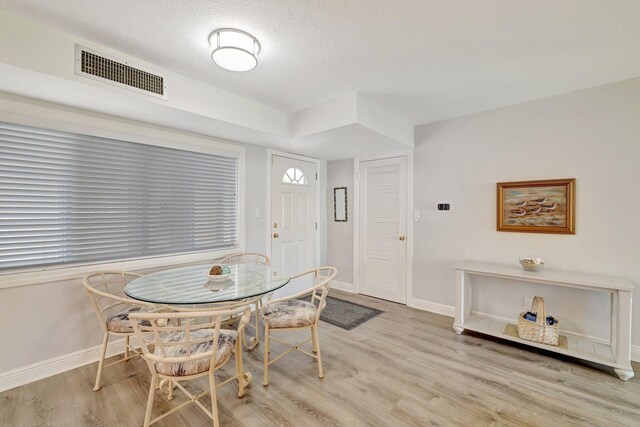 2400 S Ocean Dr Unit C623, Hutchinson Island, FL 34949 - dining space featuring light wood-type flooring, baseboards, and a textured ceiling