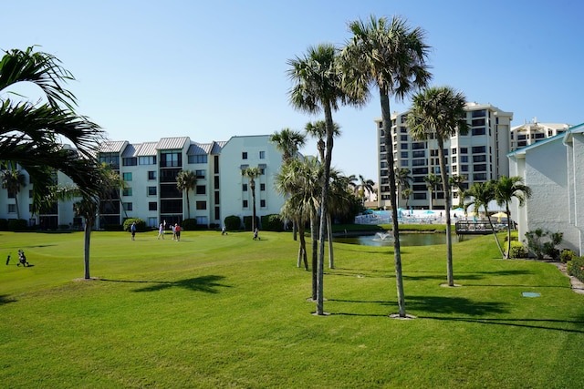 view of community with a lawn and a water view