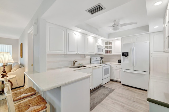 2400 S Ocean Dr Unit C623, Hutchinson Island, FL 34949 - kitchen with white appliances, a sink, a peninsula, glass insert cabinets, and a breakfast bar area
