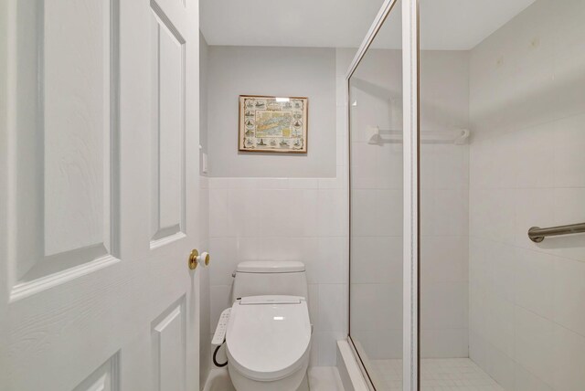2400 S Ocean Dr Unit C623, Hutchinson Island, FL 34949 - bathroom with toilet, a shower stall, and tile walls