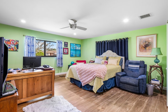 bedroom with light wood finished floors, visible vents, a ceiling fan, and baseboards