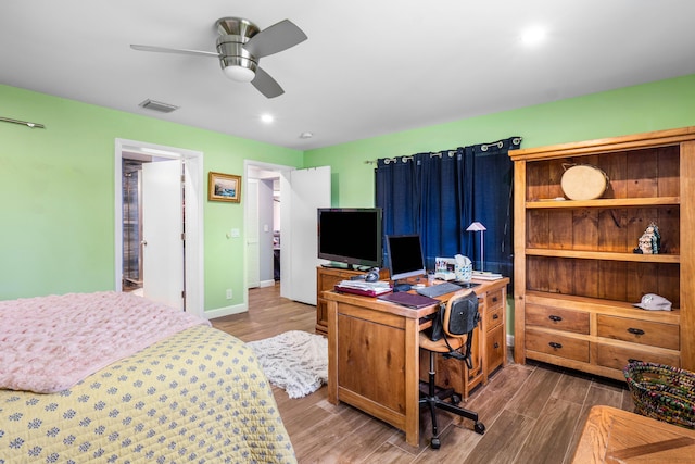 bedroom featuring visible vents, a ceiling fan, baseboards, and wood finished floors