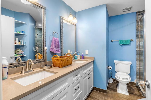 bathroom with a sink, toilet, wood finished floors, and a shower stall