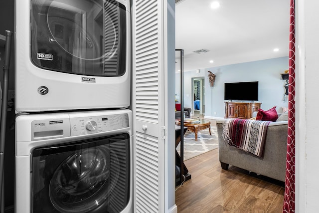 clothes washing area featuring wood finished floors, visible vents, laundry area, recessed lighting, and stacked washer / dryer