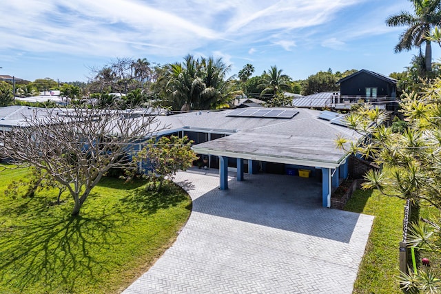 exterior space with decorative driveway and an attached carport