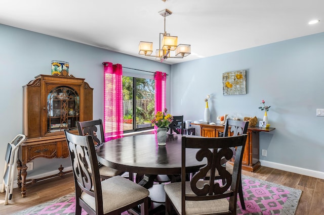 dining room with a notable chandelier, baseboards, and wood finished floors