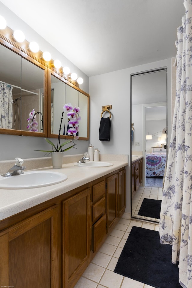 bathroom featuring a sink, connected bathroom, double vanity, and tile patterned flooring