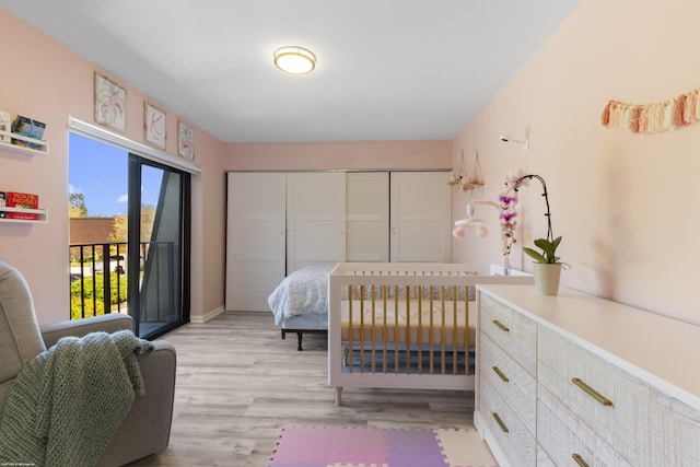 bedroom with light wood-type flooring, baseboards, and access to outside