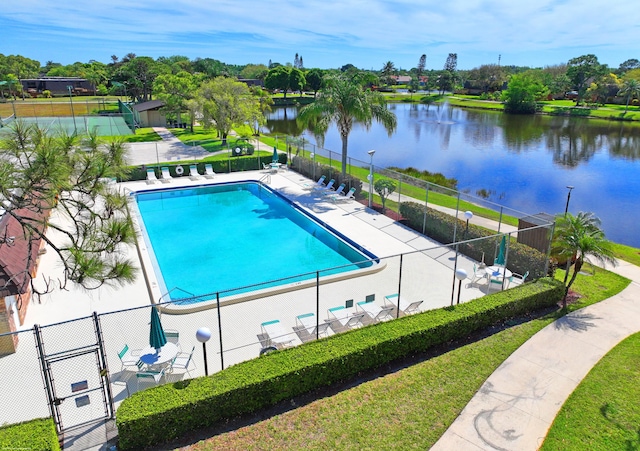 community pool featuring a gate, a water view, a patio, and fence