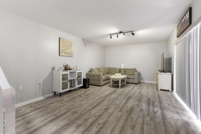 unfurnished living room with wood finished floors and baseboards