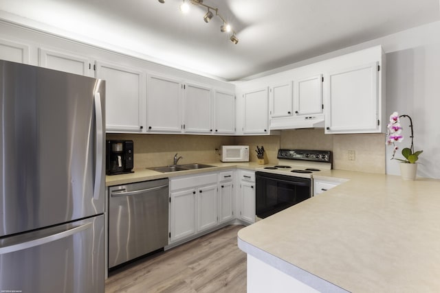 kitchen featuring under cabinet range hood, stainless steel appliances, light countertops, and a sink