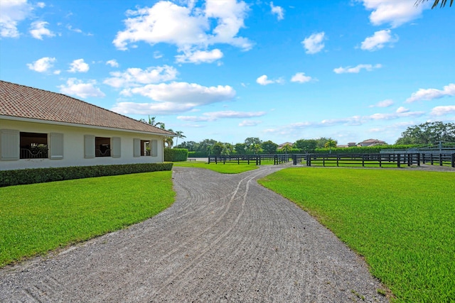 view of community featuring a lawn and fence