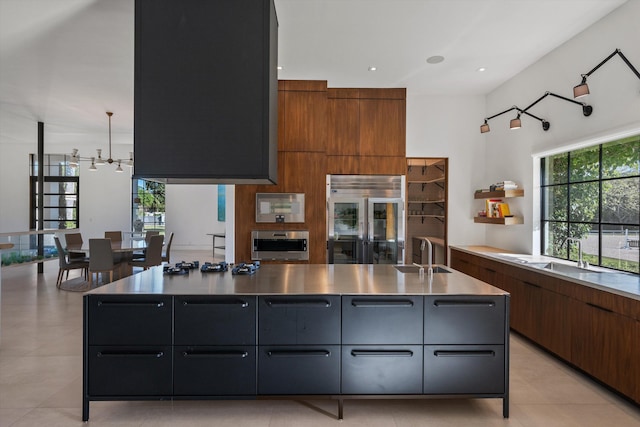 kitchen featuring brown cabinetry, appliances with stainless steel finishes, modern cabinets, and a sink