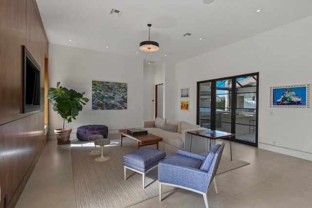 living area featuring recessed lighting, visible vents, a towering ceiling, and baseboards