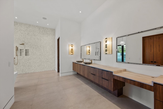 bathroom featuring vanity, tile patterned flooring, recessed lighting, and a towering ceiling