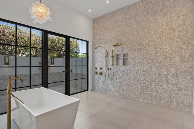 bathroom with recessed lighting, a freestanding tub, and a towering ceiling