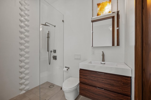 bathroom featuring vanity, a tile shower, tile walls, toilet, and tile patterned floors