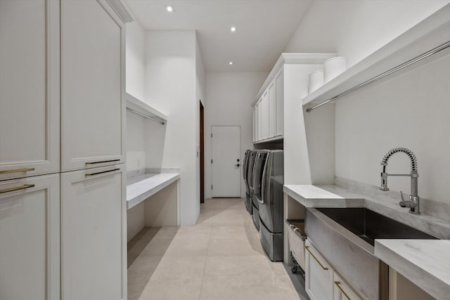 laundry room featuring light tile patterned floors, recessed lighting, separate washer and dryer, cabinet space, and a sink