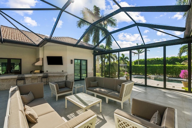 view of patio / terrace featuring an outdoor hangout area, a jacuzzi, glass enclosure, and outdoor dry bar