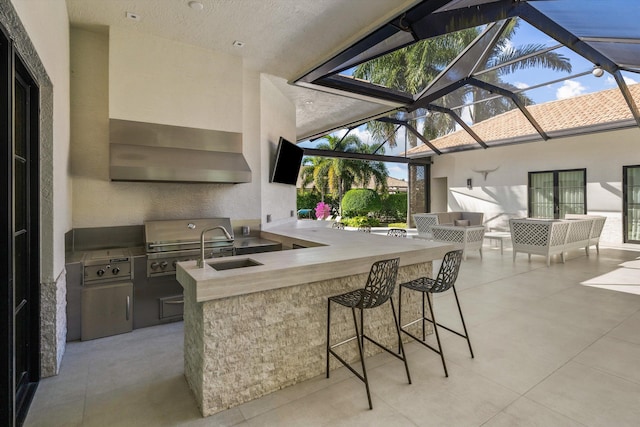 view of patio / terrace featuring a lanai, outdoor wet bar, an outdoor kitchen, and grilling area