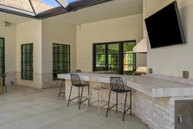 view of patio featuring a lanai and outdoor dry bar