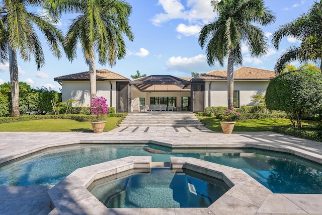 view of pool with a lanai, a yard, a patio area, and a pool with connected hot tub