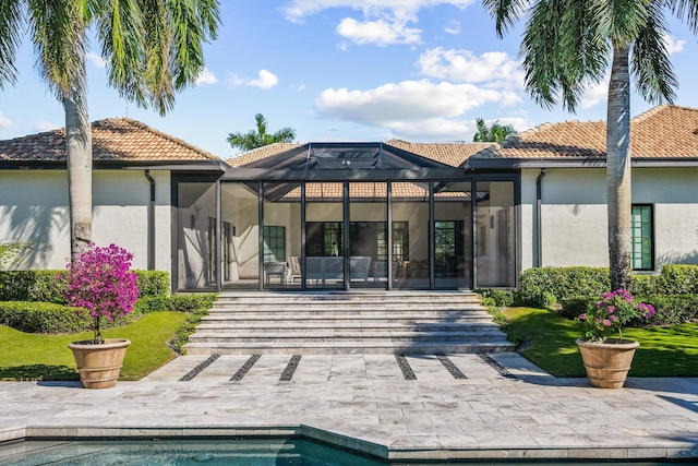 back of property featuring a patio, an outdoor pool, a tile roof, and a lanai