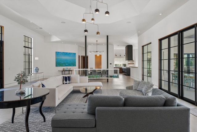 living room with a raised ceiling, recessed lighting, and a chandelier