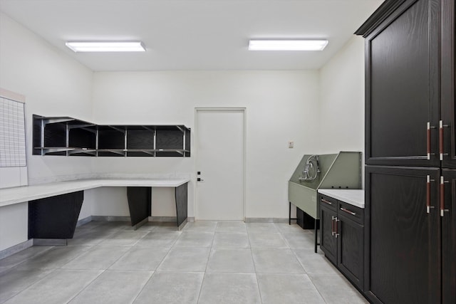 interior space featuring light tile patterned flooring and baseboards