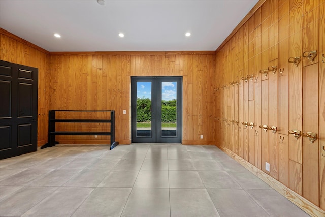 entryway with tile patterned floors, french doors, wooden walls, and recessed lighting