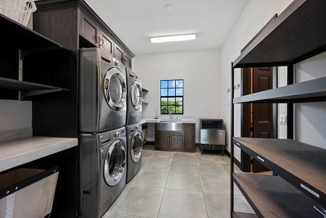 clothes washing area featuring heating unit, washing machine and clothes dryer, light tile patterned flooring, cabinet space, and stacked washer and dryer