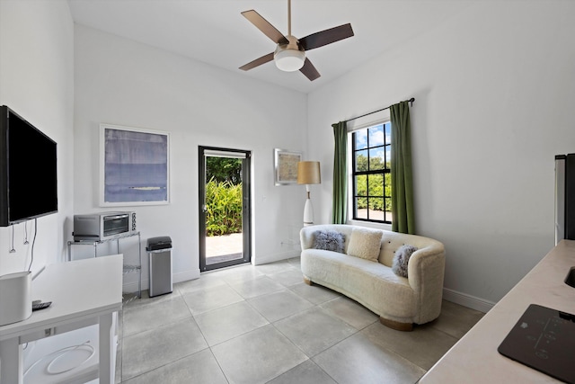 office space with baseboards, ceiling fan, and light tile patterned flooring