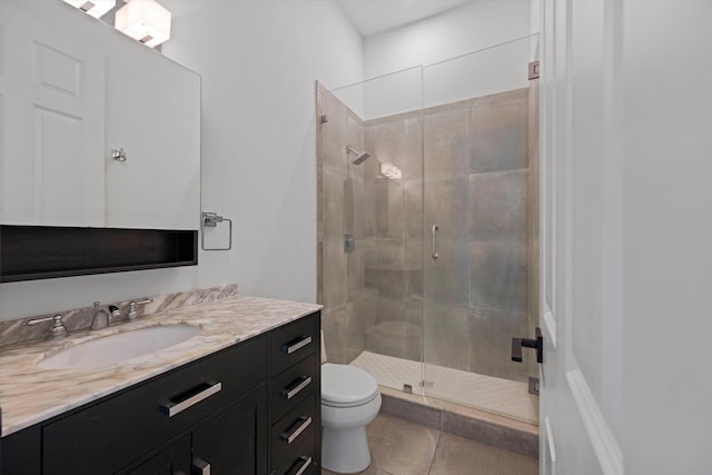 bathroom with vanity, a shower stall, toilet, and tile patterned floors