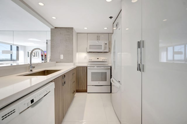 kitchen with white appliances, recessed lighting, a sink, light countertops, and modern cabinets