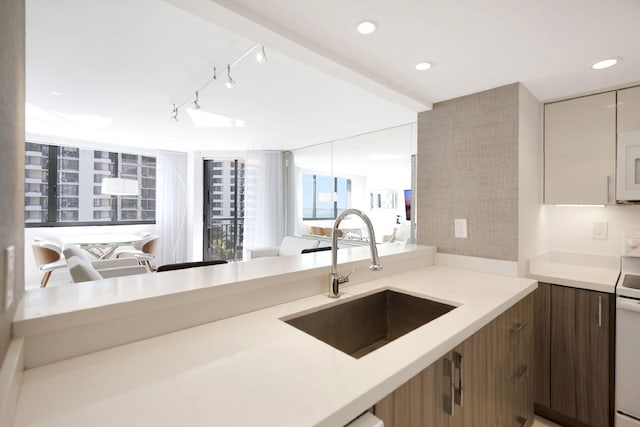 kitchen with white appliances, recessed lighting, a sink, light countertops, and modern cabinets