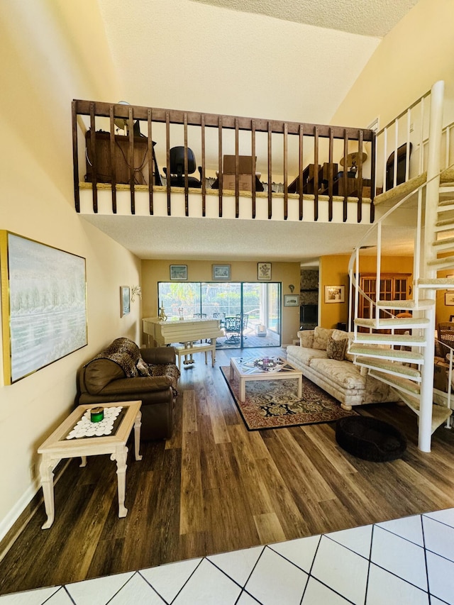 living room with high vaulted ceiling, stairway, and wood finished floors