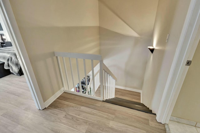 staircase with wood finished floors and baseboards