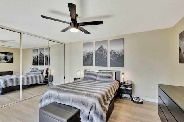 bedroom featuring a closet, baseboards, light wood-style flooring, and a ceiling fan