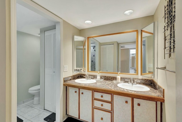 full bathroom featuring a sink, a closet, double vanity, and tile patterned flooring