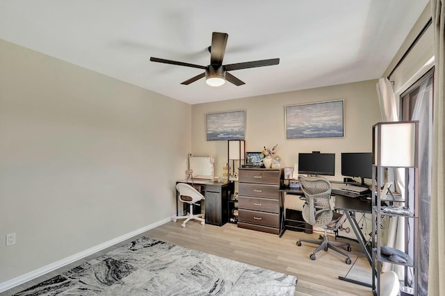 home office with a ceiling fan, baseboards, and light wood-type flooring