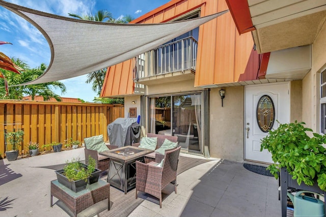 view of patio / terrace with grilling area, a fire pit, a balcony, and fence