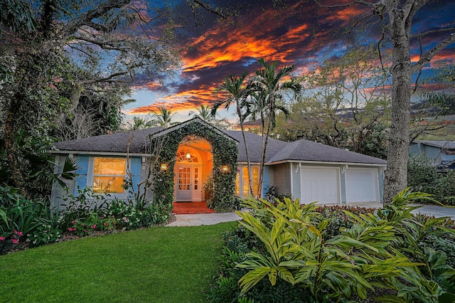 view of front of property featuring a lawn, an attached garage, and stucco siding