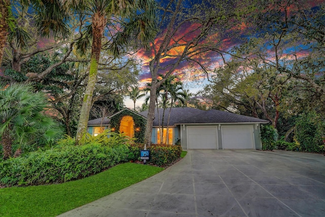 view of front facade featuring stucco siding, concrete driveway, and an attached garage