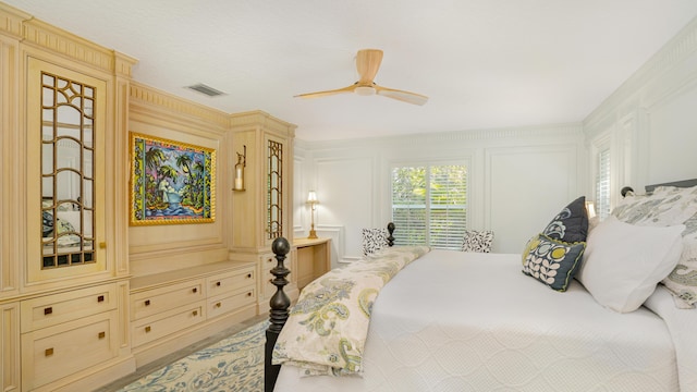 bedroom with visible vents, ceiling fan, and a decorative wall