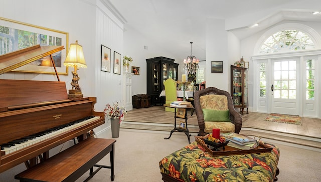 living area featuring carpet floors, high vaulted ceiling, and an inviting chandelier