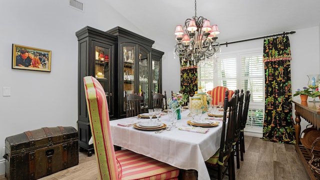 dining space with a notable chandelier, visible vents, and wood finished floors