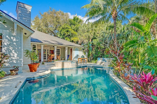 view of swimming pool with a patio area and a pool with connected hot tub