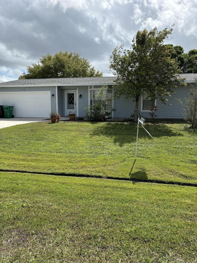 ranch-style home featuring a garage, a front lawn, and driveway